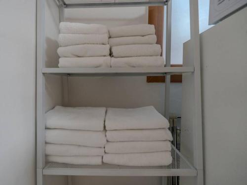 a stack of towels on a shelf in a bathroom at Hongdae Cozy in Seoul
