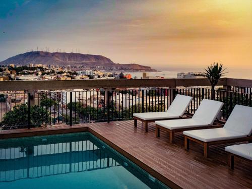 un balcón con sillas y una piscina con vistas. en LIMA lounge stylish SUITE, en Lima
