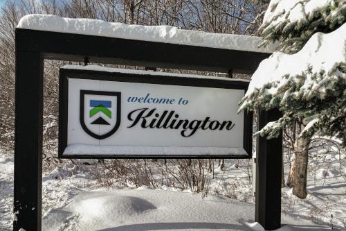 um sinal que diz bem-vindo ao enchimento na neve em Mountain Green em Killington