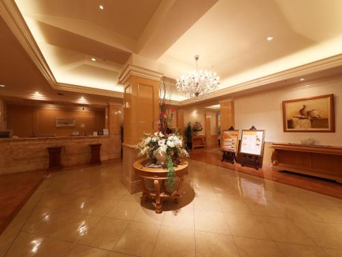 a large lobby with a flower arrangement in the middle at Hotel Fine Garden Toyonaka Osaka International Itami Airport in Toyonaka