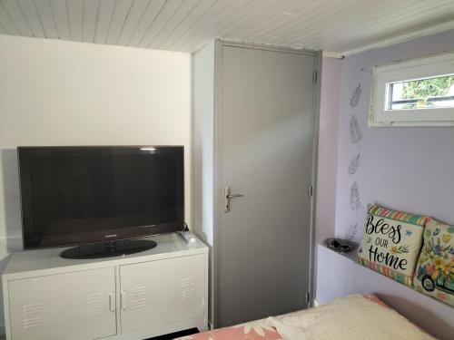a bedroom with a flat screen tv on a white cabinet at Studio très calme 5mn VICHY in Bellerive-sur-Allier