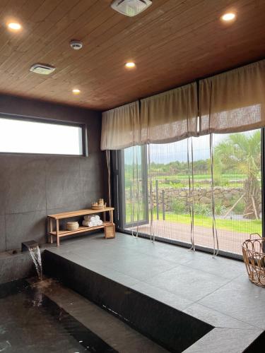a living room with a large window and a couch at On Stay Jeju in Jeju
