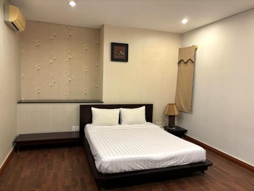a bedroom with a bed with white sheets at Kim Tho Hotel in Can Tho