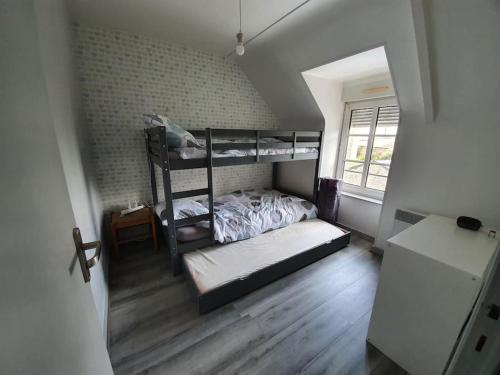 une chambre avec deux lits superposés dans une pièce dans l'établissement Maison dans un quartier calme, terrain, wifi, télé, à Saint-Nicolas-du-Pélem