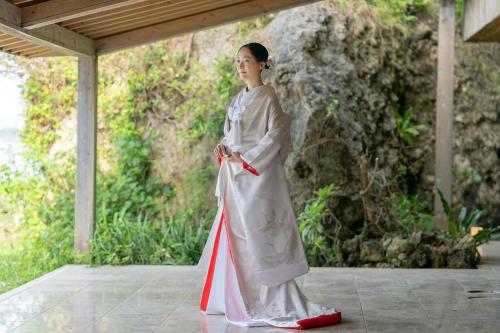 a woman in a kimono holding a flag at Hyakunagaran in Nanjo
