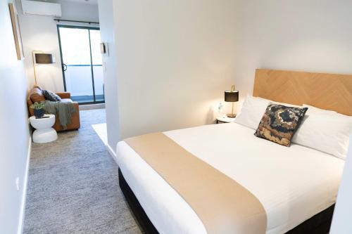 a bedroom with a large white bed in a room at Amica Serviced Apartments in Orange