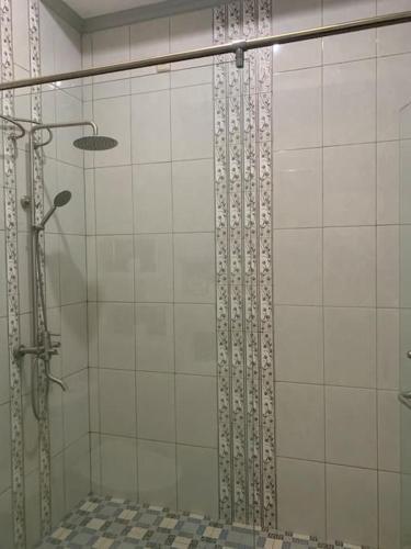 y baño con ducha y puerta de cristal. en Homestay Mutiara, en Yogyakarta