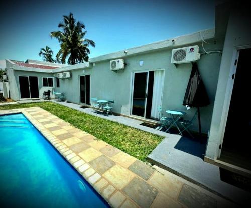 a house with a swimming pool in front of a house at Guesthouse MALAGUETA INN II in Maputo