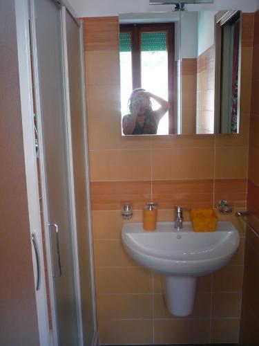 a woman taking a picture of a sink in a bathroom at Terrazza sul Mare in Giulianova