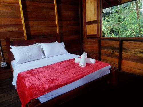 uma cama com um urso de peluche sentado em cima dela em Paraíso Verde Lodge em Quibdó