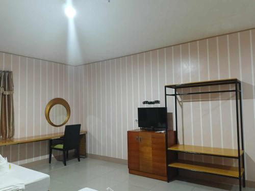 Habitación con espejo, TV y silla. en Asia Novo Boutique Hotel - Daet, en Daet
