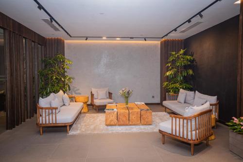 a living room with couches and chairs and plants at Hotel Barahi Kathmandu in Kathmandu