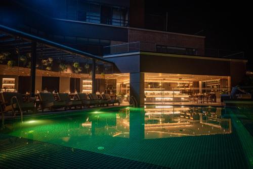 a swimming pool with chairs and a building at night at Hotel Barahi Kathmandu in Kathmandu
