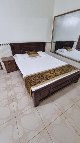 a bed in a room with a large mirror at Hương Giang Hotel & Coffee in Thái Bình