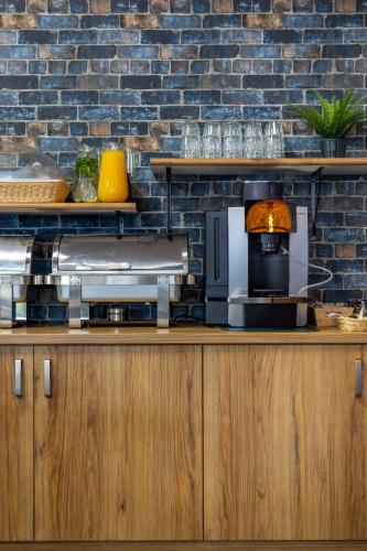 a kitchen with wooden cabinets and a brick wall at Hotel A4 Wrocław - Bielany in Bielany Wrocławskie