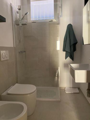 a bathroom with a shower and a toilet and a sink at Gabe in Cesena
