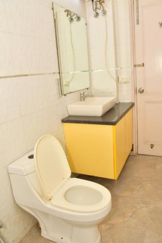 a bathroom with a toilet and a sink at Hotel Nirvana Suites in New Delhi