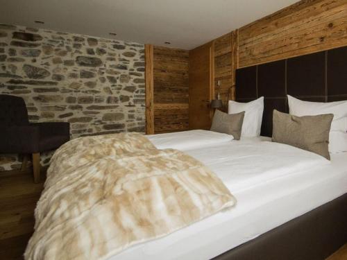 a large bed in a room with a stone wall at Lovely apartment in Schröcken in Schröcken