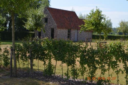 an old stone house with trees in front of it at Woestyne Business & Leisure Apartments Cleythil in Aalter