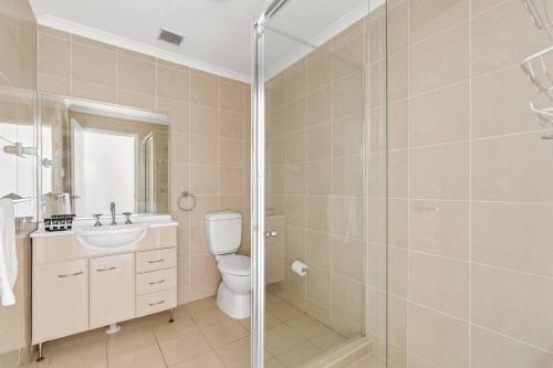 Un baño con inodoro, lavabo y ducha. en Surf at Avalon Beach and Laze on the Private Terrace, en Avalon