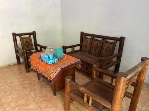 um quarto com duas cadeiras e uma mesa e uma mesa e cadeiras em OYO 93784 Kost Bu Eli Syariah em Ngadipuro