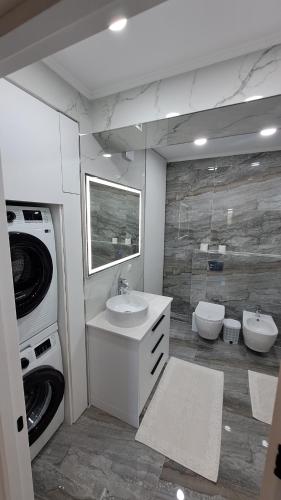 a bathroom with a sink and a washing machine at Аэропорт-Номера 24/24 . in Chişinău