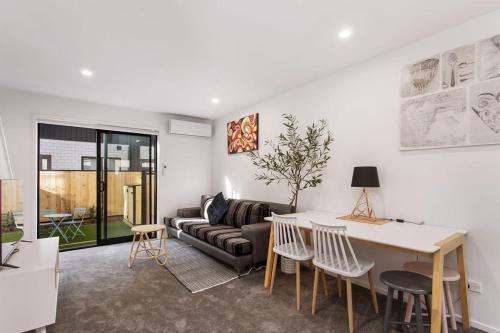 a living room with a couch and a table at New 2Bdrm 2Brm Hospital CBD Hagley Park Locationn in Christchurch