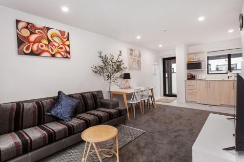 a living room with a couch and a table at New 2Bdrm 2Brm Hospital CBD Hagley Park Locationn in Christchurch
