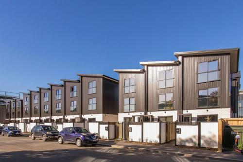 a building with cars parked in a parking lot at New 2Bdrm 2Brm Hospital CBD Hagley Park Locationn in Christchurch
