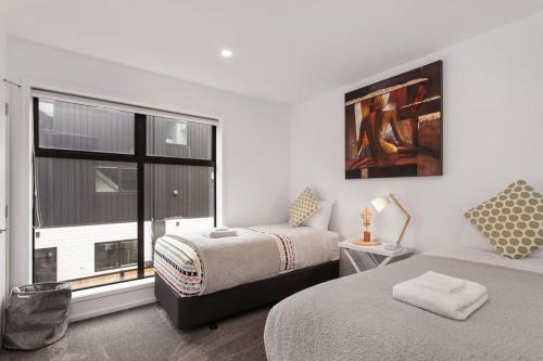 a bedroom with two beds and a large window at New 2Bdrm 2Brm Hospital CBD Hagley Park Locationn in Christchurch