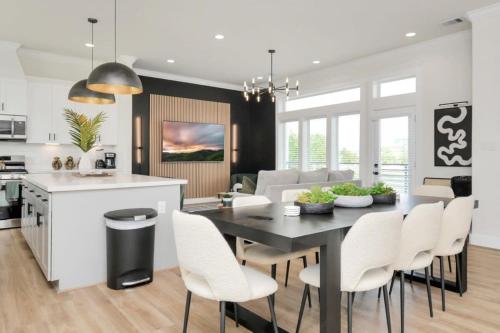 eine Küche und ein Esszimmer mit einem schwarzen Tisch und weißen Stühlen in der Unterkunft Paradise Palace Best Rooftop in HTX w Hot Tub in Houston