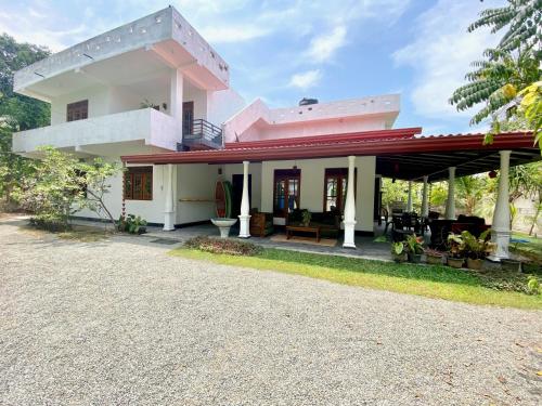 a house with a pink roof and a driveway at MAKAI Surf House in Ahangama
