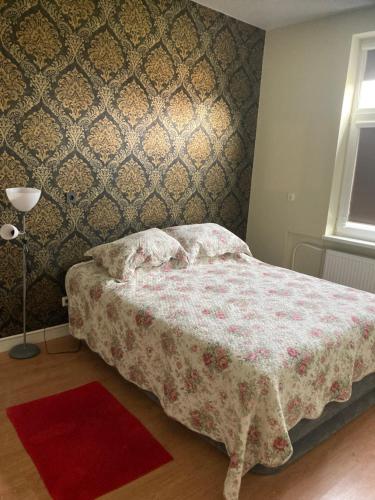 um quarto com uma cama com um tapete vermelho em Apartamentai Rusnėje , Nemuno 13 em Rusne