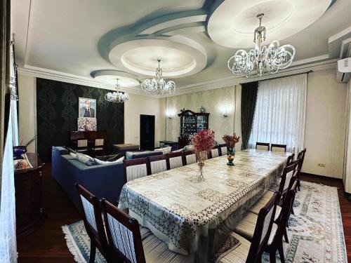 a dining room with a table and a couch at Saule Guest House in Shymkent