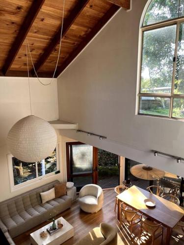 a living room with a couch and a table at The Tree House Byron Bay in Byron Bay