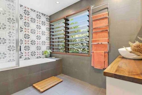 a bathroom with a tub and a sink at The Tree House Byron Bay in Byron Bay