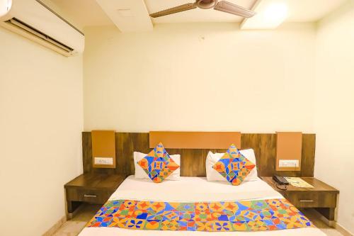 a bedroom with a bed with colorful pillows at FabHotel Krishna in Nagpur