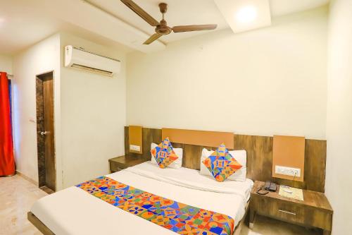 a bedroom with two beds and a ceiling fan at FabHotel Krishna in Nagpur