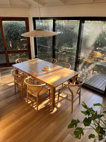 a dining room table with chairs and an umbrella at The Tree House Byron Bay in Byron Bay