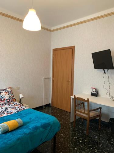 Dormitorio con cama, escritorio y TV en Erzelli's House Apt B con 2 camere by SMART-HOME en Génova