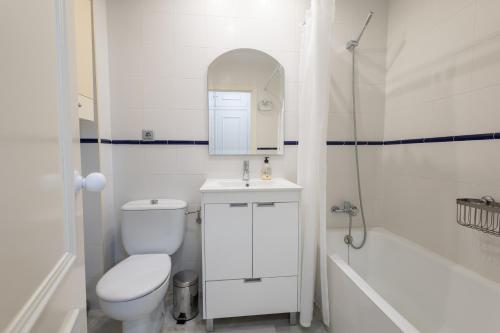 uma casa de banho branca com um WC, um lavatório e uma banheira em Piso de playa con piscinas em Motril