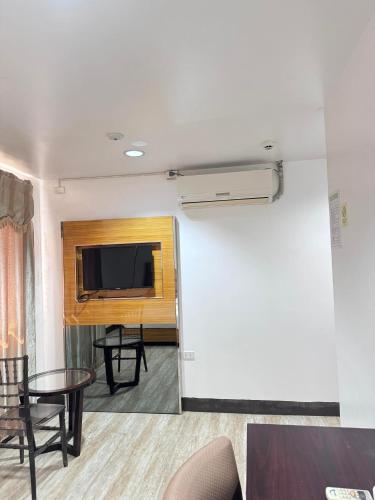 a living room with a tv and a couch and a table at Jeamco Royal Hotel-Palawan in Puerto Princesa City