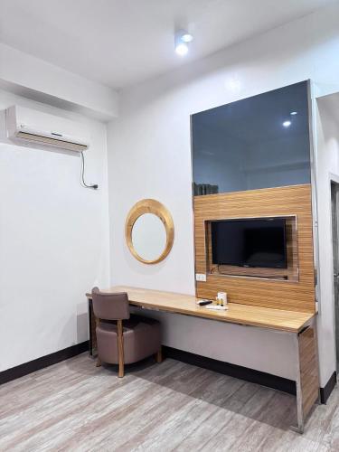 a room with a desk with a tv and a mirror at Jeamco Royal Hotel-Palawan in Puerto Princesa City