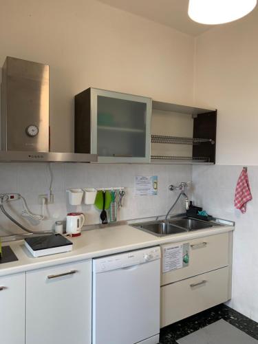 una cocina con armarios blancos y fregadero en Erzelli's House Apt B con 2 camere by SMART-HOME en Génova