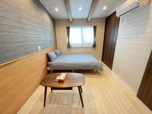 a small room with a bed and a table at 蝉時雨－大正 in Osaka