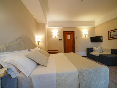 a hotel room with a bed and a couch at Hotel Scapolatiello in Cava deʼ Tirreni