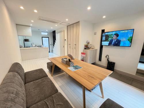 a living room with a couch and a table and a tv at 蝉時雨－大正 in Osaka