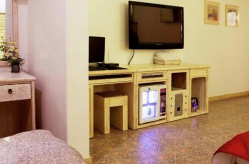 a living room with a television on a wooden stand at Asan Paradise in Asan