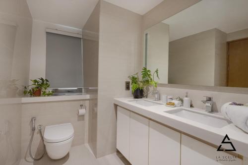 a bathroom with a toilet and a sink and a mirror at ALTAIR Apartment by TS in Colombo