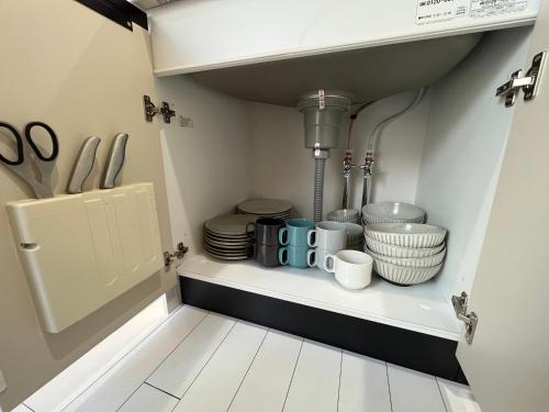 a shelf with dishes and utensils in a kitchen at 蝉時雨－大正 in Osaka